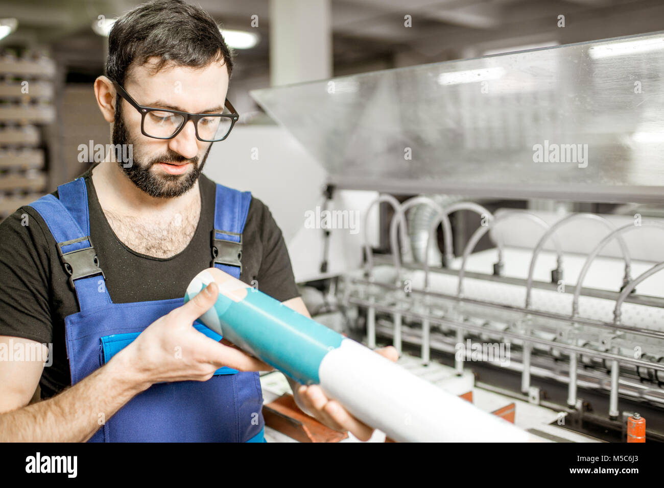 Uomo con tubo di carta a livello di fabbricazione Foto Stock