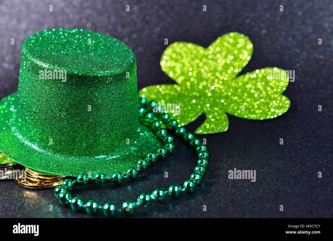 Il giorno di San Patrizio shiny green top hat, oro 3 foglia di trifoglio, monete d'oro e verde brillante perle irlandese. Foto Stock
