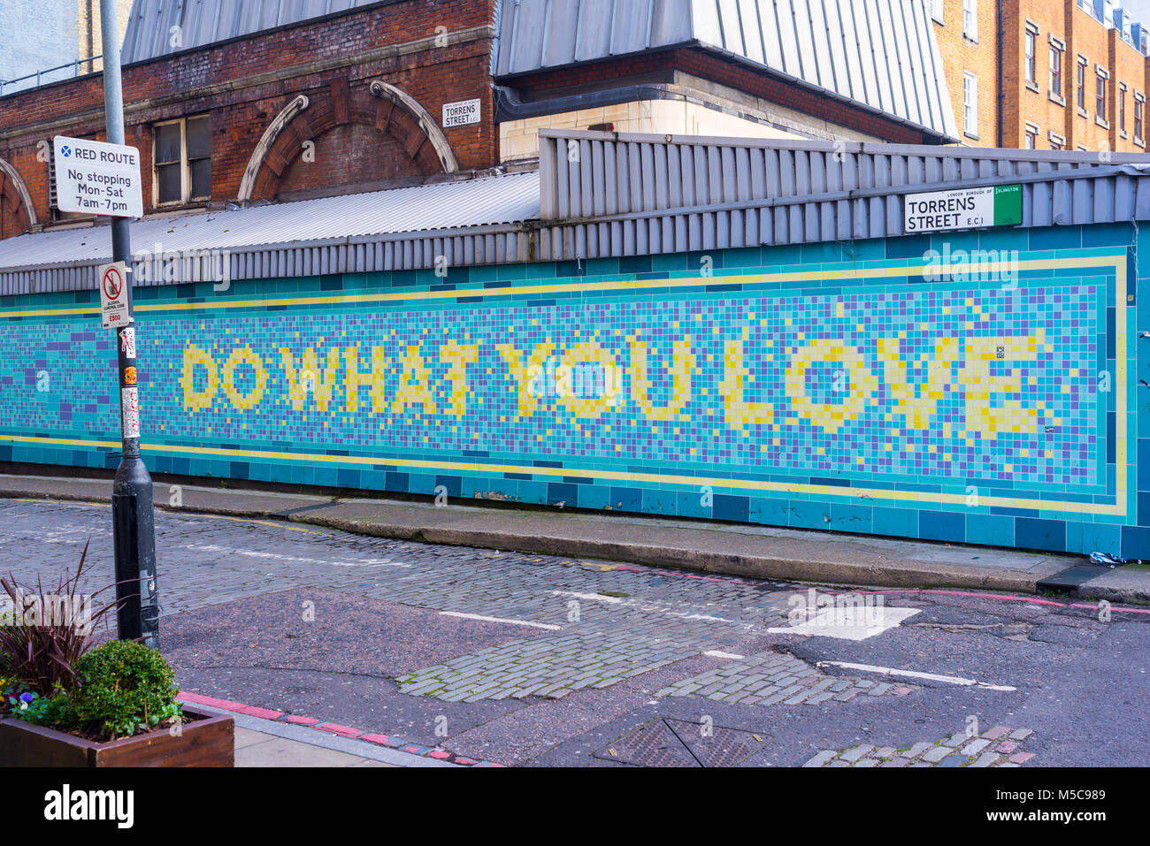 Fate ciò che amate scritto su piastrelle in torrens Street, Angelo, Islington, London, Regno Unito Foto Stock