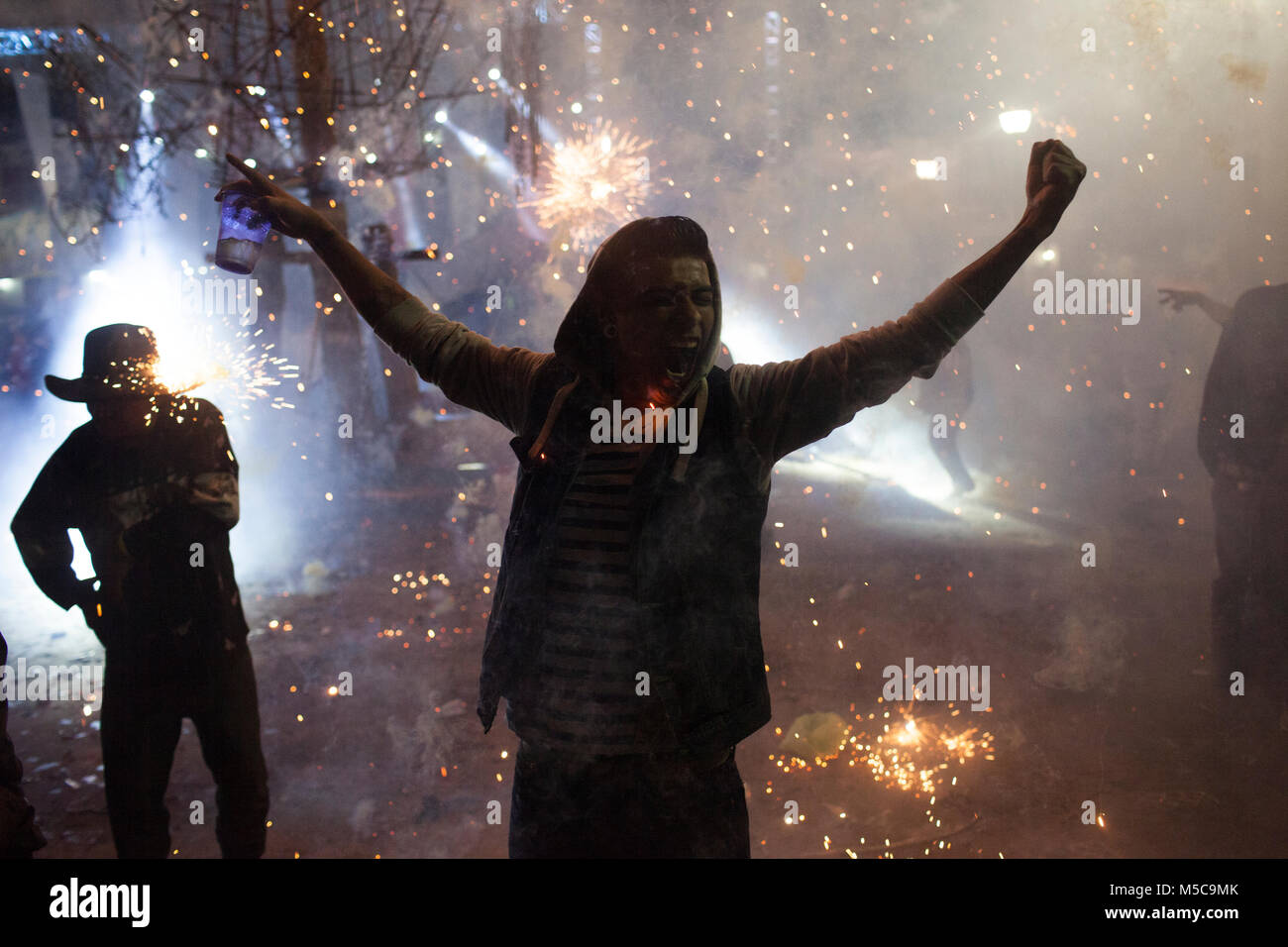 Persone corrono attraverso fuochi d'artificio durante la caduta fiesta in Cheran, Michoacan, Messico domenica 5 ottobre 2014. La città di Cheran detiene due feste annuali per celebrare la loro cultura e le loro credenze religiose. In aprile 2011, dopo anni di estorsione dal locale i cartelli e il compiacimento del Governo locale e di polizia, il popolo di Cheran recuperato il loro paese e la loro terra. Il Pueblo (tradotto come persone o comunità) di fronte al cartello, rimosso il governo da ufficio e ha creato la propria forza di polizia a guardia della città. Foto Stock
