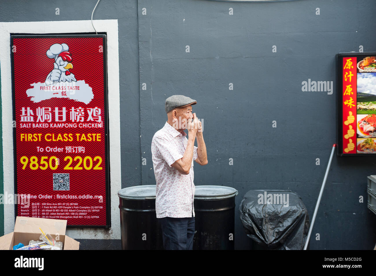 17.12.2017, Singapore, Repubblica di Singapore, in Asia - un uomo anziano parla al telefono a Singapore il quartiere Chinatown. Foto Stock