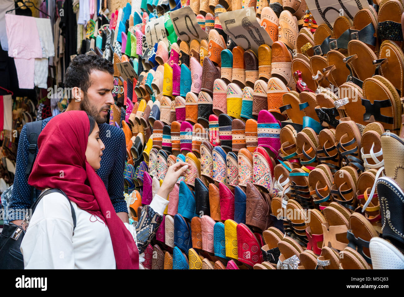 Coppia musulmana shopping cuoio marocchino pantofole in open market store Foto Stock
