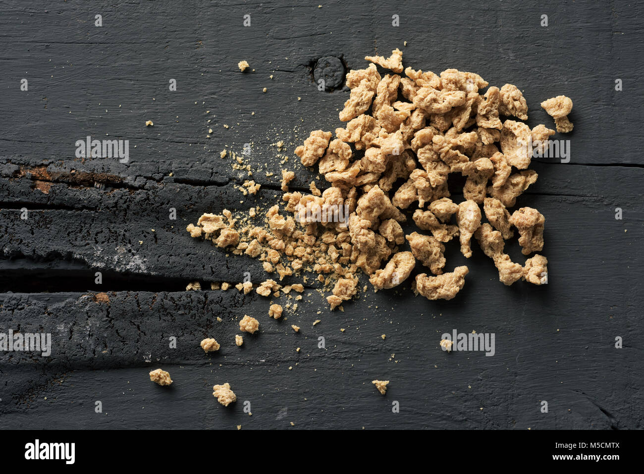 Angolo di alta vista di alcuni pezzi di trama di proteina di soia sul grigio di una tavola in legno rustico Foto Stock