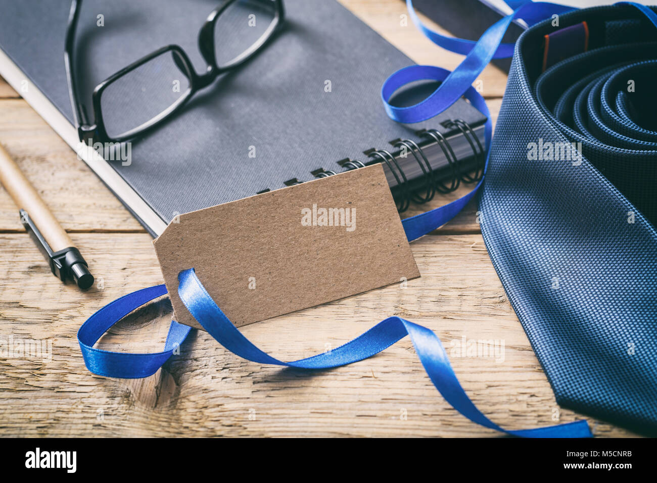 La festa del papà concetto. Cravatta blu con un fustellato tag vuoto, ufficio sfondo scrivania Foto Stock