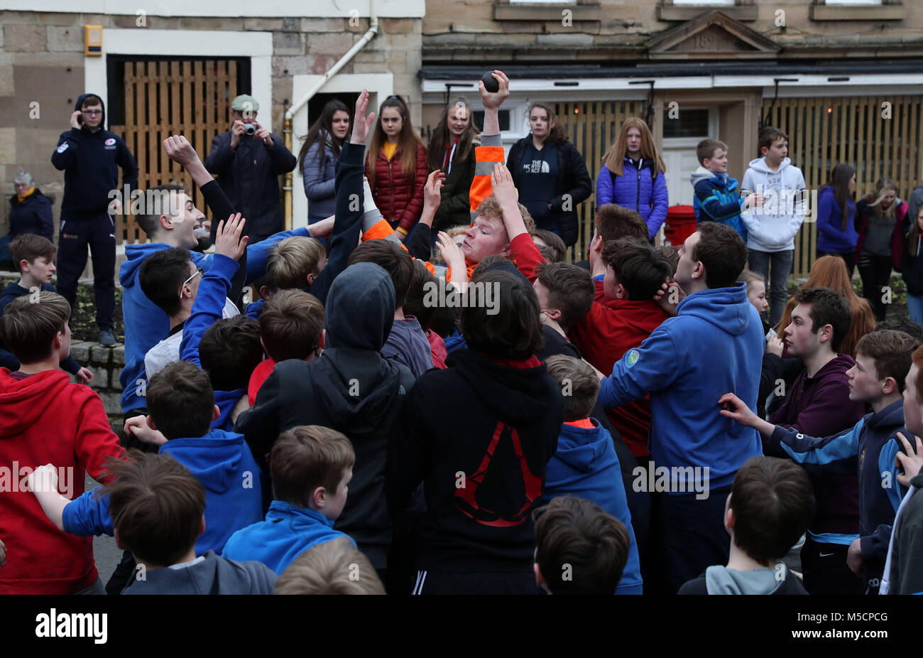 Ragazzi bagarre per il pallone in pelle durante l'annuale "Fastern Eve Handba' evento su Jedburgh's High Street in Scottish Borders. La manifestazione annuale, iniziata nel 1700, comporta due squadre, la Uppies (residenti nella parte alta di Jedburgh) e i Doonies (residenti a partire dalla parte inferiore di Jedburgh) ottenendo la palla verso la parte superiore o inferiore della città. La sfera, il quale è realizzato in pelle, imbottito con paglia e decorata con nastri è gettato in mezzo alla folla per iniziare il gioco. Foto di credito dovrebbe leggere: Andrew Milligan/filo PA. Foto Stock