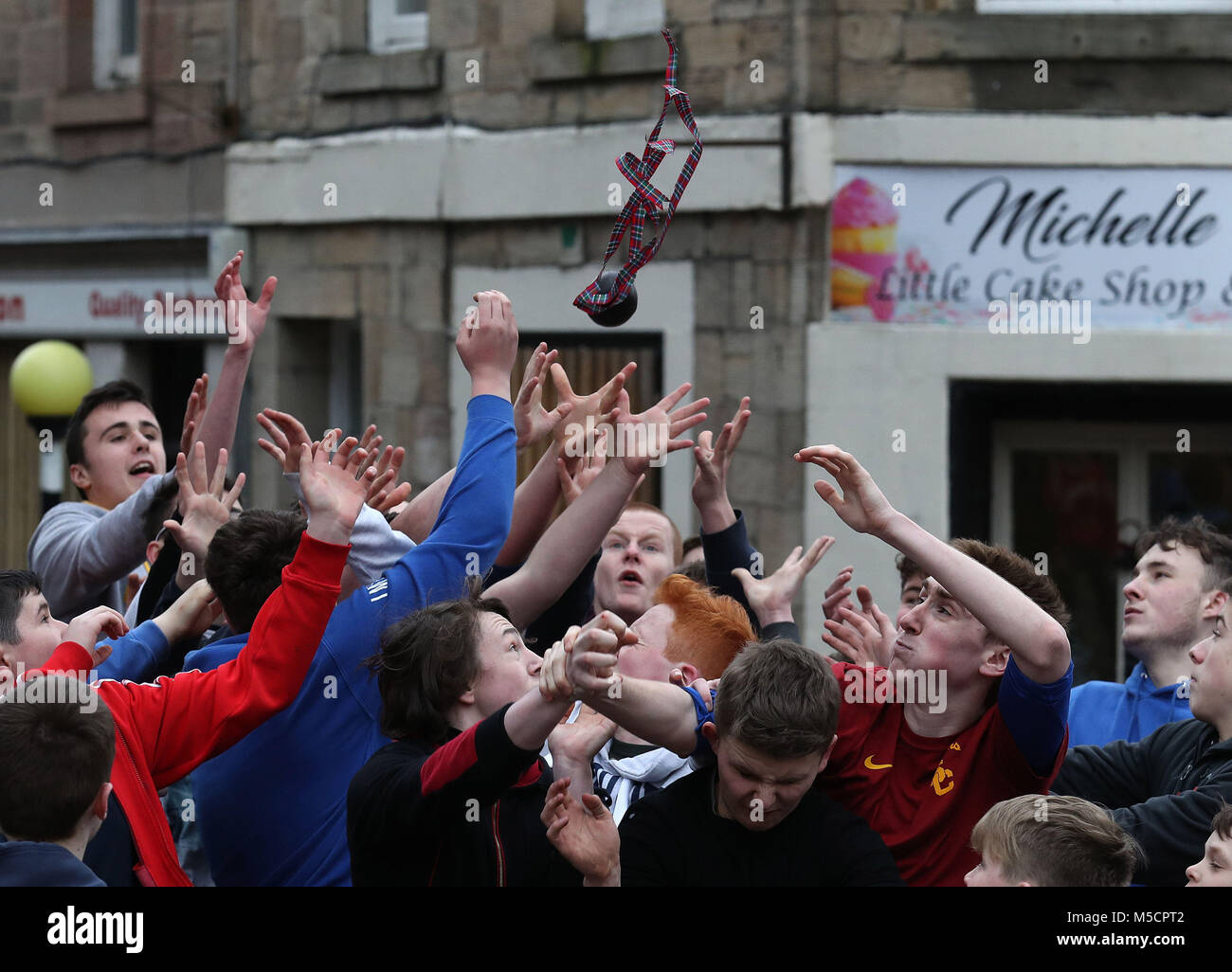 Ragazzi bagarre per il pallone in pelle durante l'annuale "Fastern Eve Handba' evento su Jedburgh's High Street in Scottish Borders. La manifestazione annuale, iniziata nel 1700, comporta due squadre, la Uppies (residenti nella parte alta di Jedburgh) e i Doonies (residenti a partire dalla parte inferiore di Jedburgh) ottenendo la palla verso la parte superiore o inferiore della città. La sfera, il quale è realizzato in pelle, imbottito con paglia e decorata con nastri è gettato in mezzo alla folla per iniziare il gioco. Foto di credito dovrebbe leggere: Andrew Milligan/filo PA. Foto Stock