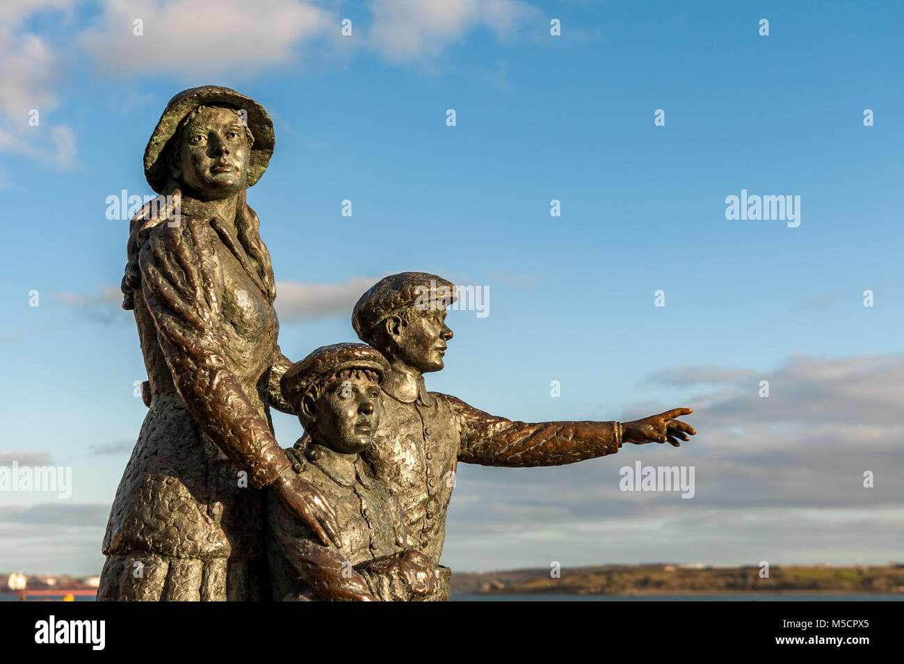 Statua di Annie Moore in Cobh, nella contea di Cork, l'Irlanda, con i suoi fratelli, prima di immigrati irlandesi negli Stati Uniti nel 1892 con copia spazio. Foto Stock