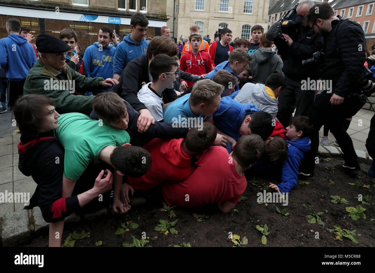 Ragazzi bagarre per il pallone in pelle durante l'annuale "Fastern Eve Handba' evento su Jedburgh's High Street in Scottish Borders. La manifestazione annuale, iniziata nel 1700, comporta due squadre, la Uppies (residenti nella parte alta di Jedburgh) e i Doonies (residenti a partire dalla parte inferiore di Jedburgh) ottenendo la palla verso la parte superiore o inferiore della città. La sfera, il quale è realizzato in pelle, imbottito con paglia e decorata con nastri è gettato in mezzo alla folla per iniziare il gioco. Foto di credito dovrebbe leggere: Andrew Milligan/filo PA. Foto Stock