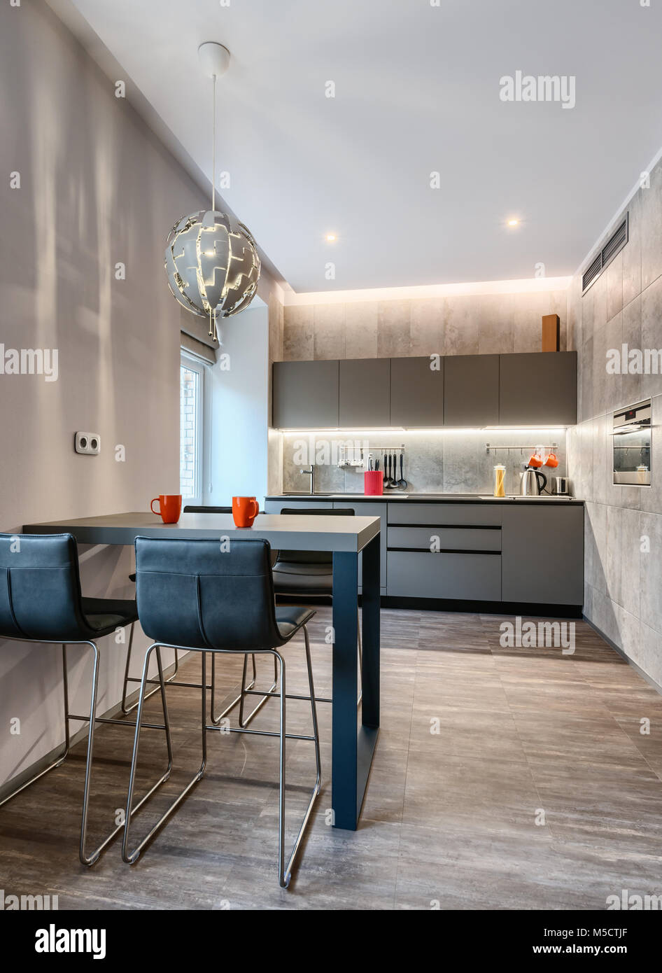 Moderna cucina con tavolo da pranzo in colore grigio Foto Stock