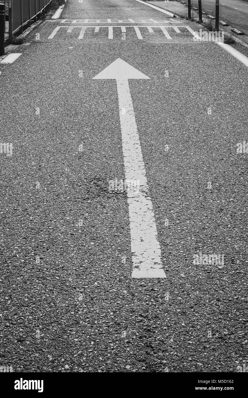 Immagine in bianco e nero di una freccia sulla strada come marcatura Foto Stock