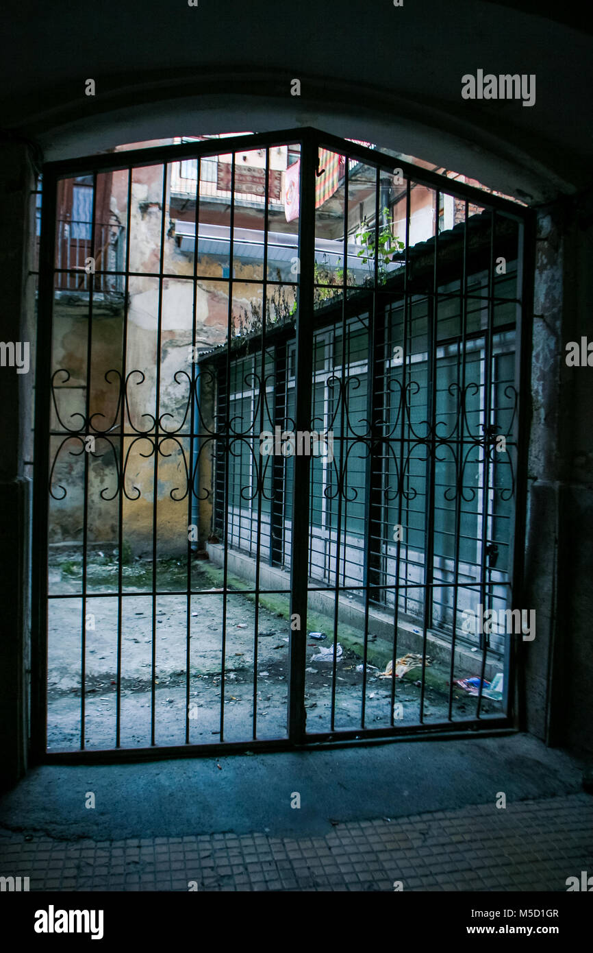 Piccola città cantiere con pareti in mattoni di antiche case attraverso il ferro metallico di gate in pizzo in città europea Lvov Foto Stock