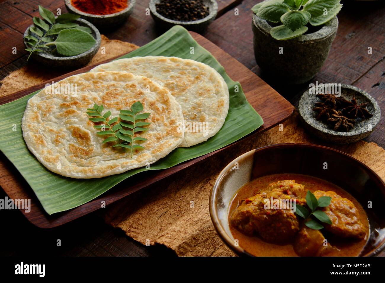 Roti Prata con pollo al curry. Indiano-influenzato piatto di pasta con pollo e curry di patate popolare in Singapore e Malesia. Foto Stock