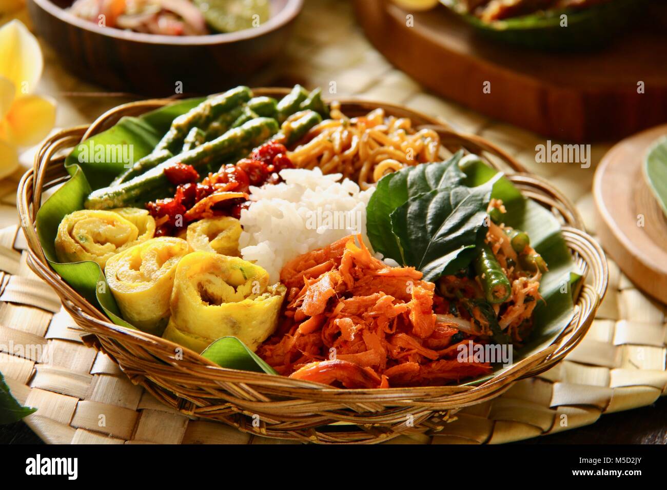 Il Nasi Campur Bali. Popolare Balinese tradizionale piatto di riso al vapore serviti con vari contorni. Foto Stock
