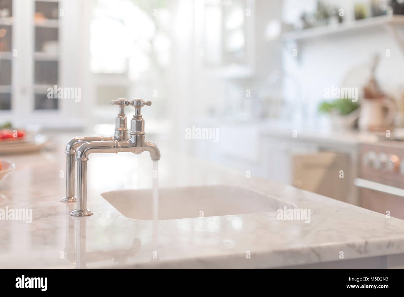 L'acqua che scorre dal rubinetto nel lavello da cucina Foto Stock