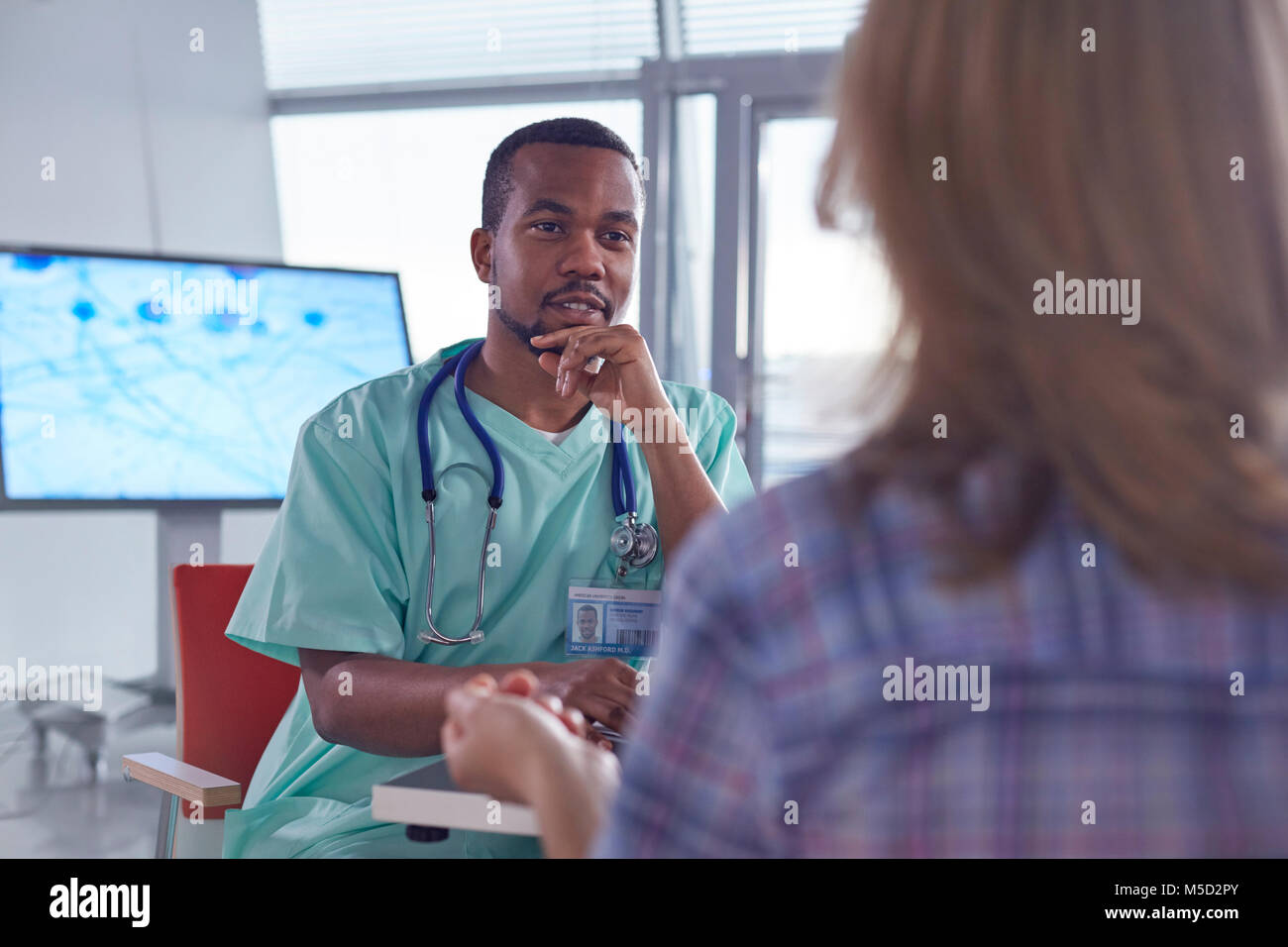 Chirurgo maschio a parlare al paziente di sesso femminile in ospedale Foto Stock