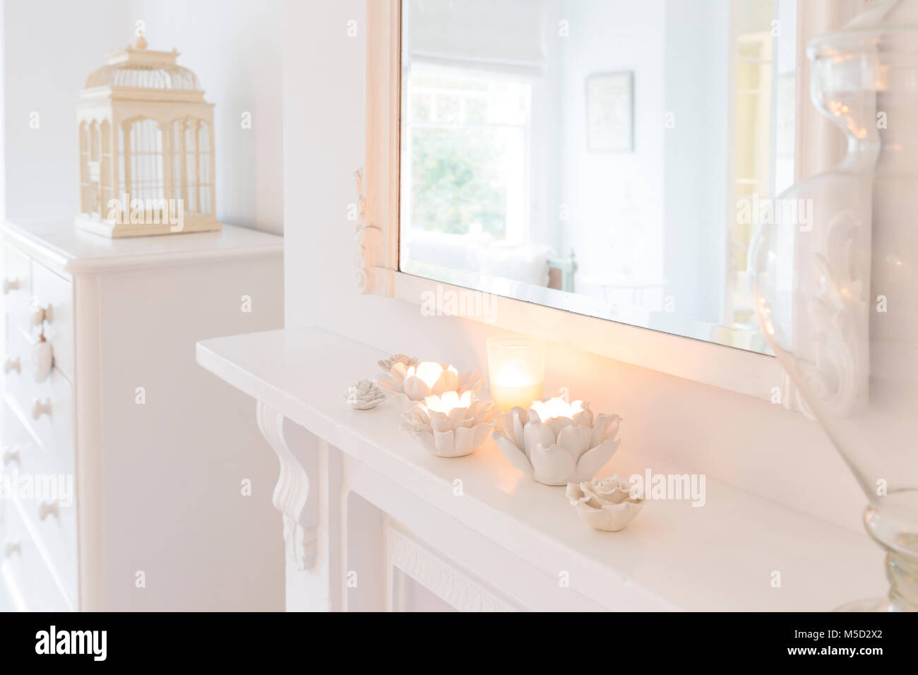 Tranquilla candele in fiore portacandele sul manto bianco Foto Stock