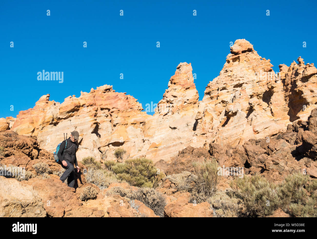 Escursionista maschio nei pressi di pomice formazioni rocciose Piedras Amarilla (rocce gialle) in Parque Nacional del Teide Tenerife, Isole Canarie, Spagna Foto Stock