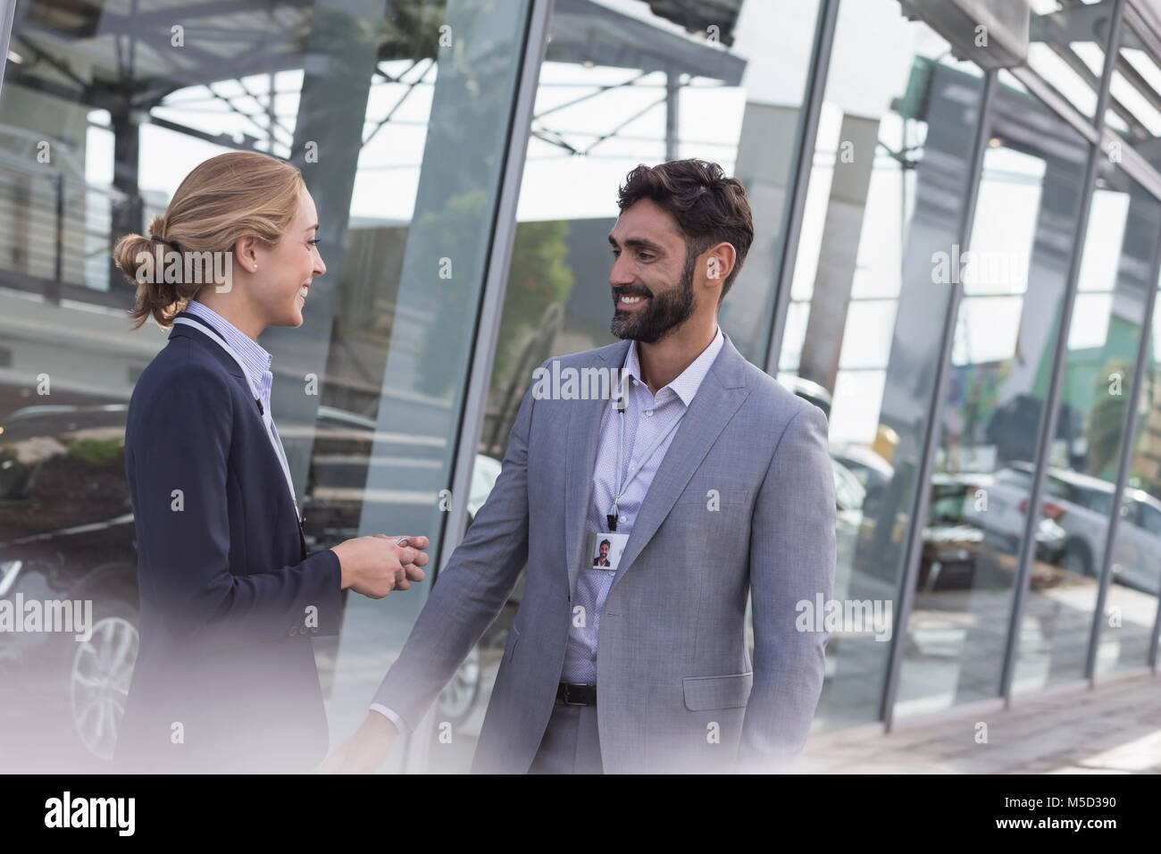 Le vendite di automobili persone che parlano al di fuori di concessionaria auto showroom Foto Stock