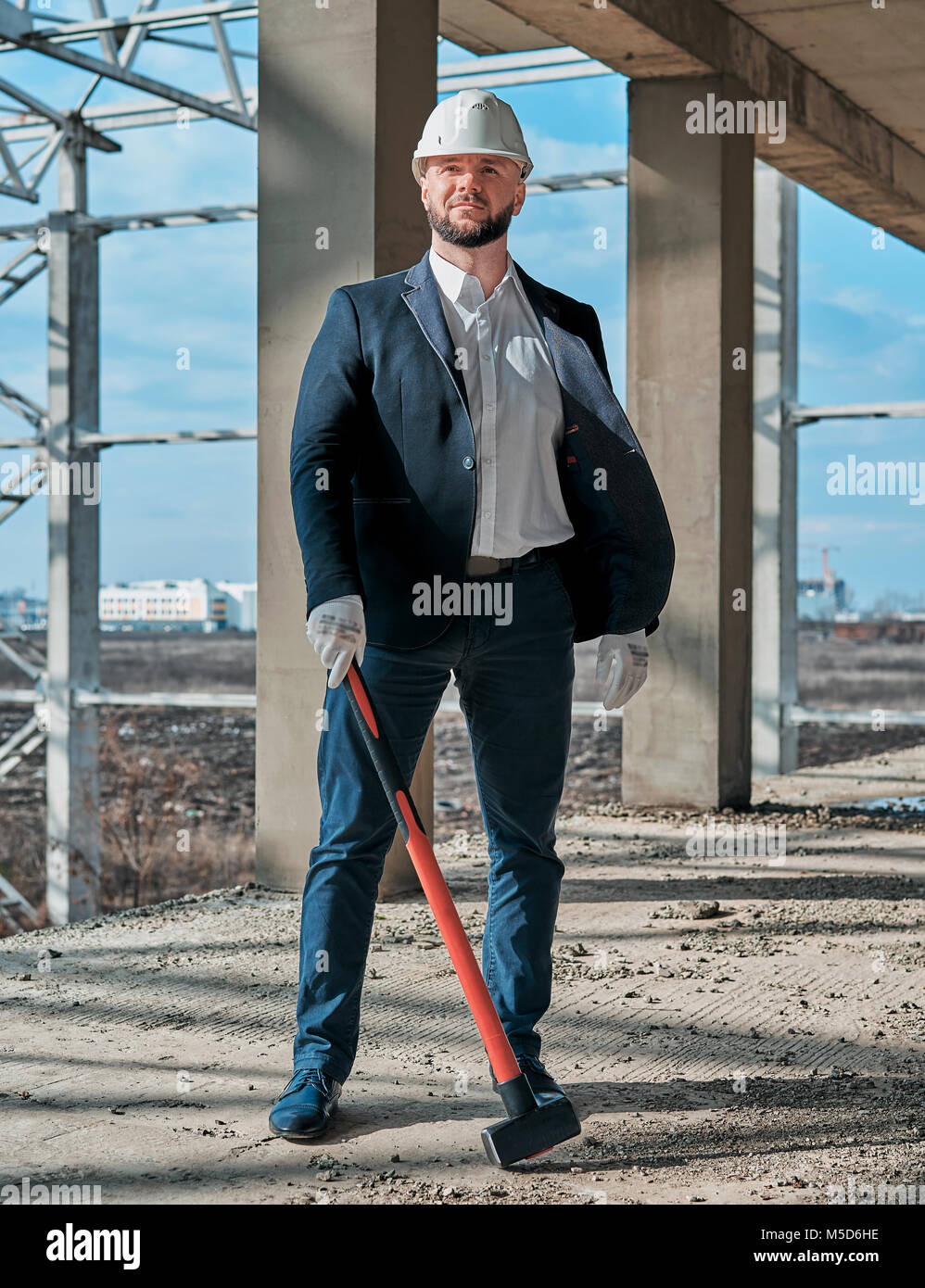 Uomo in un business suit in corrispondenza di un sito in costruzione Foto Stock