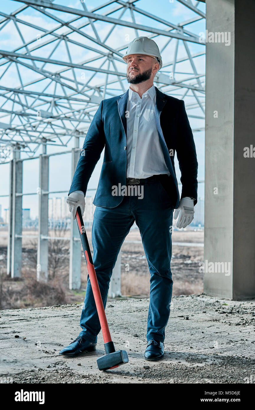 Uomo in un business suit in corrispondenza di un sito in costruzione Foto Stock