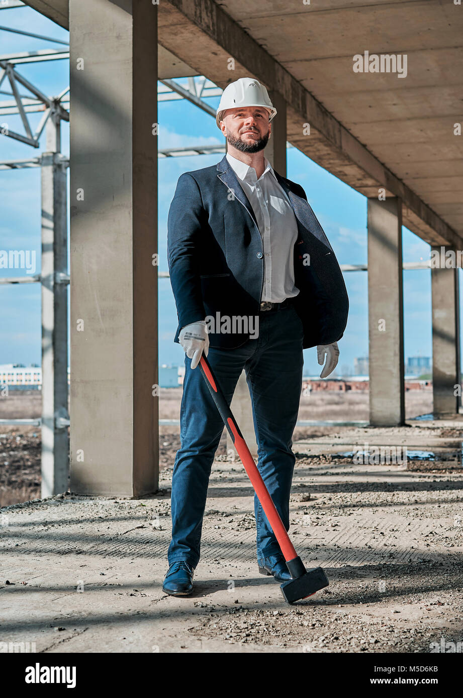 Uomo in un business suit in corrispondenza di un sito in costruzione Foto Stock