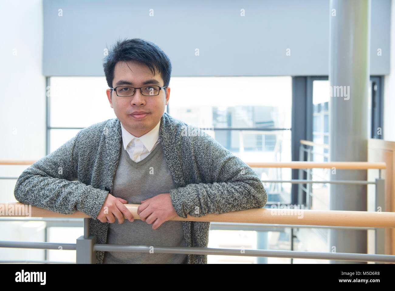 Un giovane studente di oltremare sorge intorno al campus universitario per i ritratti Foto Stock
