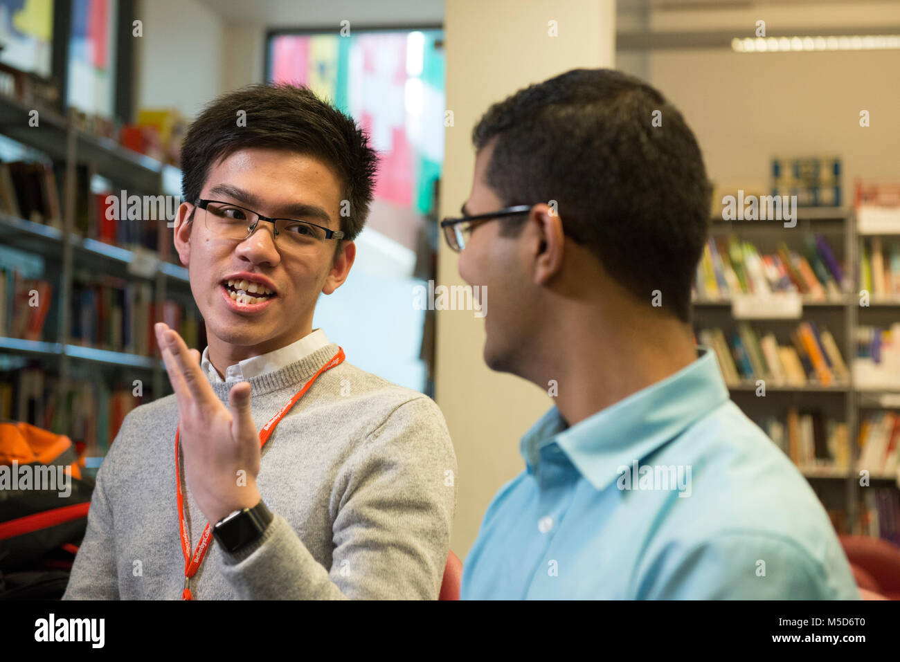 Gli studenti dei college campus prendere parte in modo organizzato un evento sociale nella libreria e sono ripresi per un video online mentre viene intervistato Foto Stock