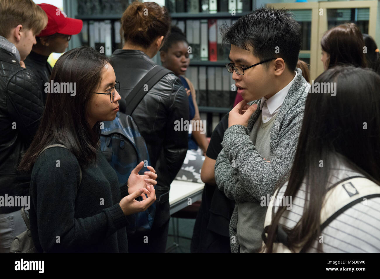 Gli studenti dei college campus prendere parte in modo organizzato un evento sociale nella libreria e sono ripresi per un video online mentre viene intervistato Foto Stock