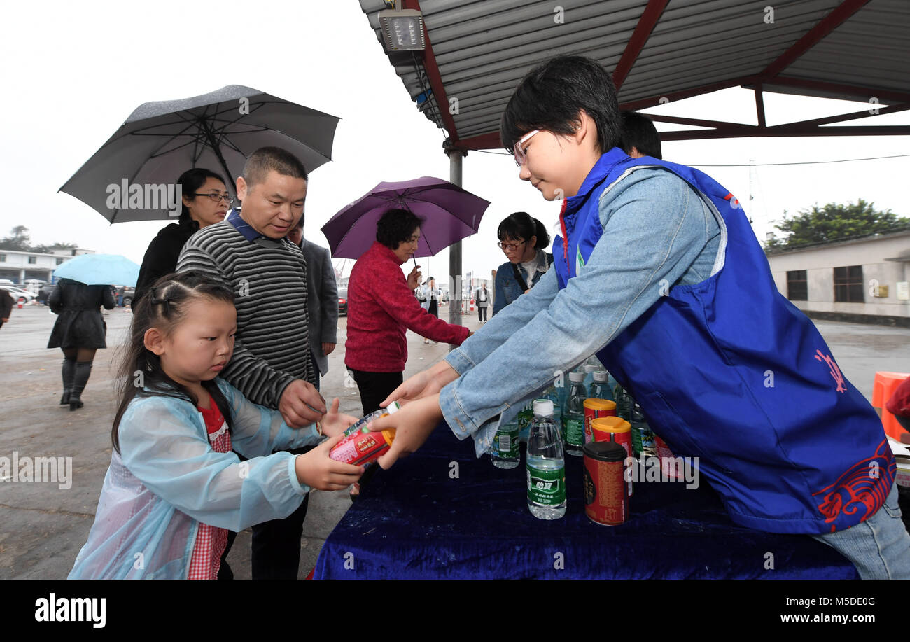 Haikou, cinese della provincia di Hainan. Il 22 febbraio, 2018. Volontari distribuiscono cibo per i turisti al porto Xiuying in Haikou, capitale del sud della Cina di Hainan Provincia, 22 febbraio, 2018. I servizi di traghetto riprende Giovedì sul Qiongzhou Strait, un gateway principale per la Cina del sud della provincia dell'isola di Hainan, ma il tempo sarà necessario per liberare il backlog di veicoli a filamento. Haikou ha impostato 237 volontario di aree di servizio per le famiglie che viaggiano tra domenica e giovedì mattina. Oltre 6.500 volontari hanno offerto il loro aiuto. Credito: Zhao Yingquan/Xinhua/Alamy Live News Foto Stock