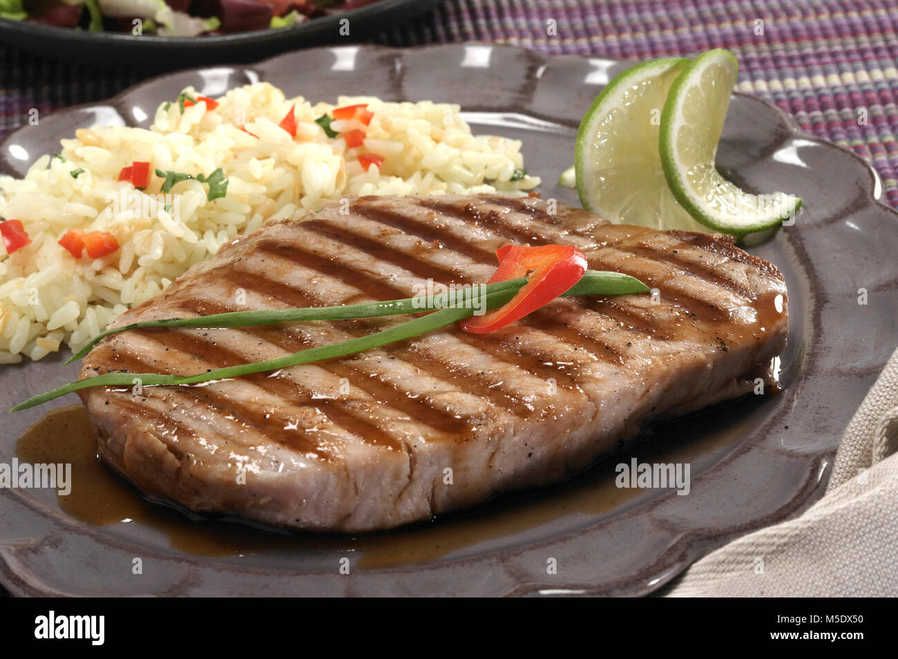 Bistecca di tonno su piastra con riso Foto Stock