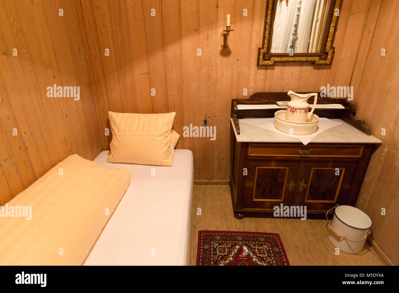 Camera in hotel, bed, boiserie, boccale acqua, lavabo, antiquariato e specchio Foto Stock