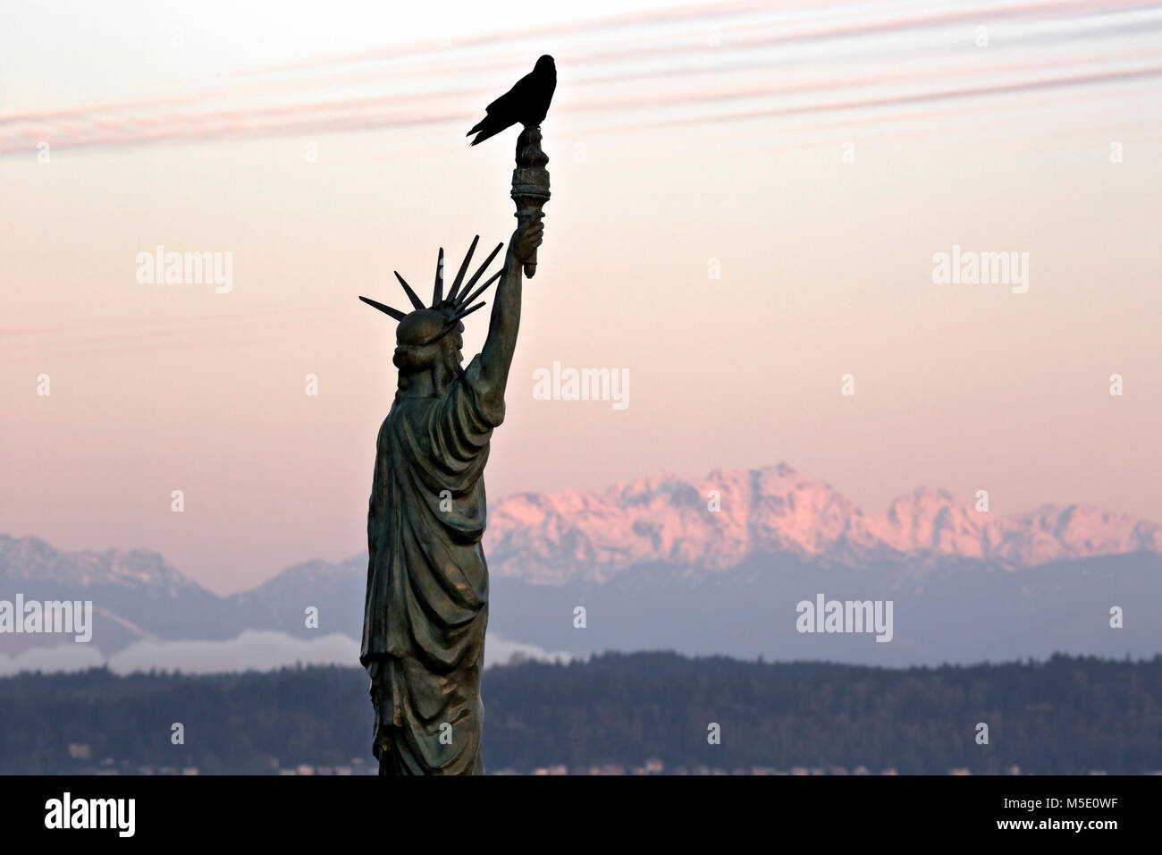 WA13612-00...WASHINGTON - Replica della Statua della libertà su Alki Beach a West Seattle con vista sulle Olympic Mountains e un corvo arroccato sulla cima.2017 Foto Stock