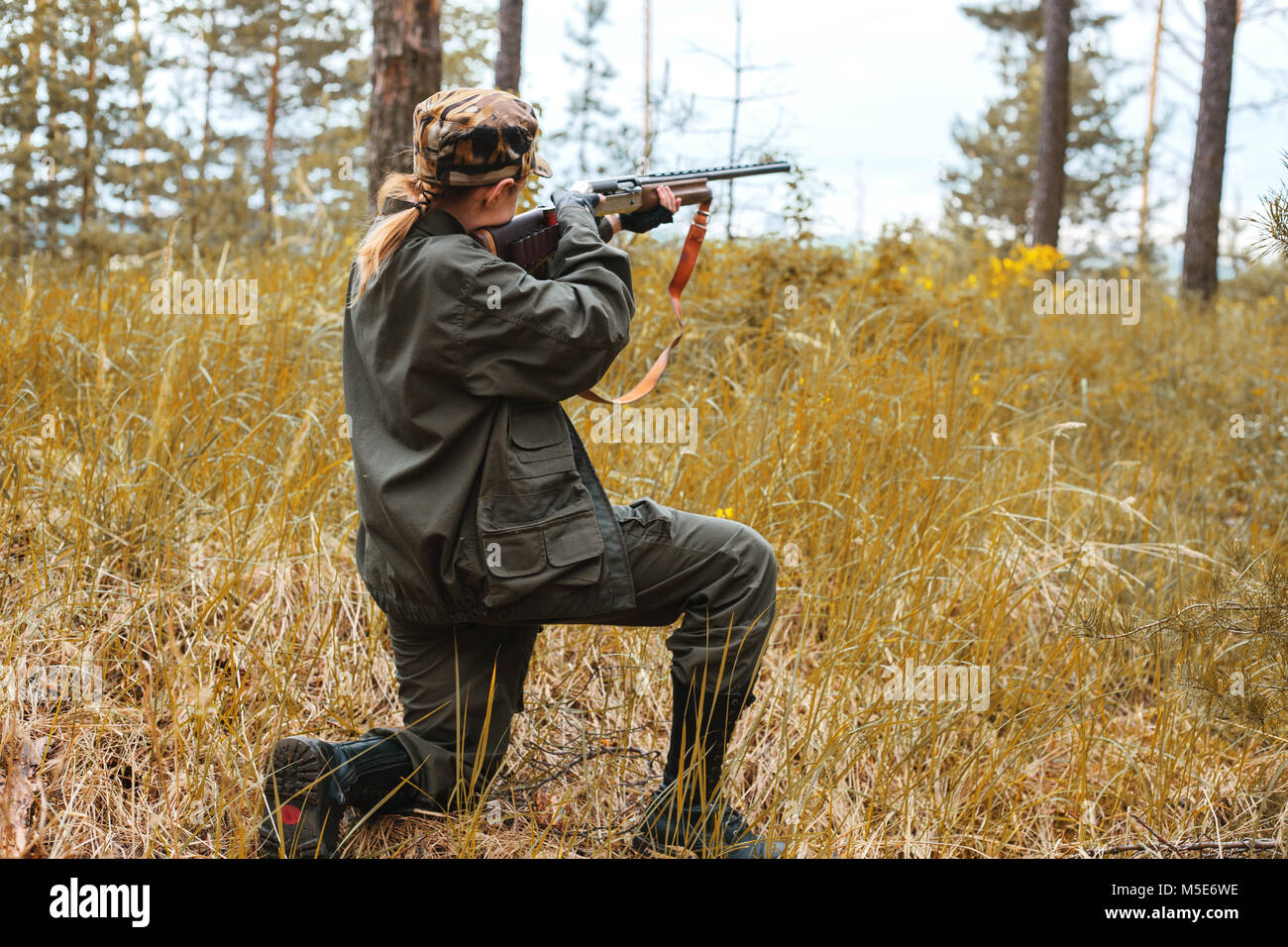 Donna hunter nel bosco. Autunno stagione di caccia. Caccia sfondo concettuale. Sport all'aperto. Foto Stock