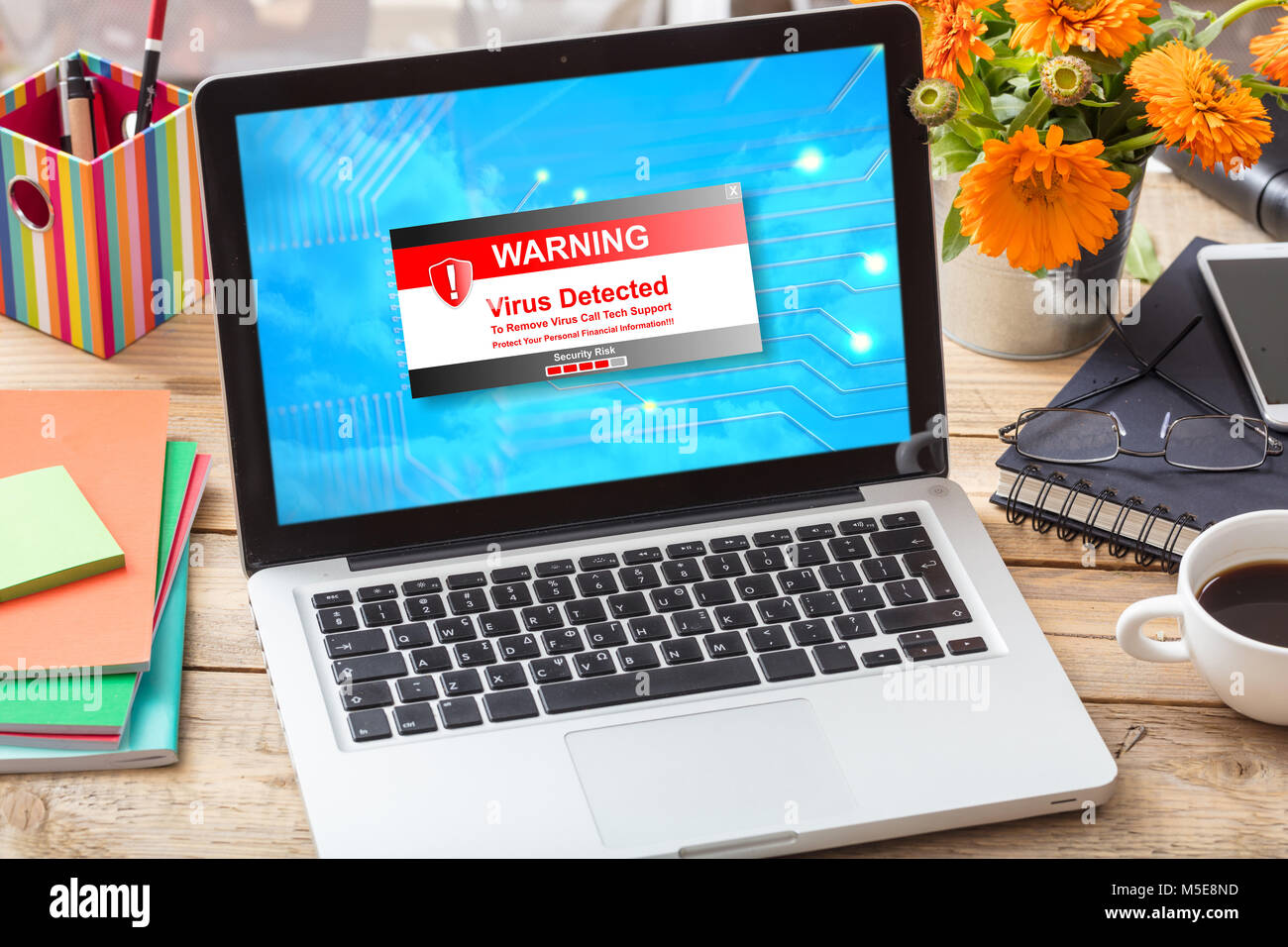 Virus rilevato il messaggio di avvertimento sullo schermo di un computer su un di legno scrivania in ufficio Foto Stock