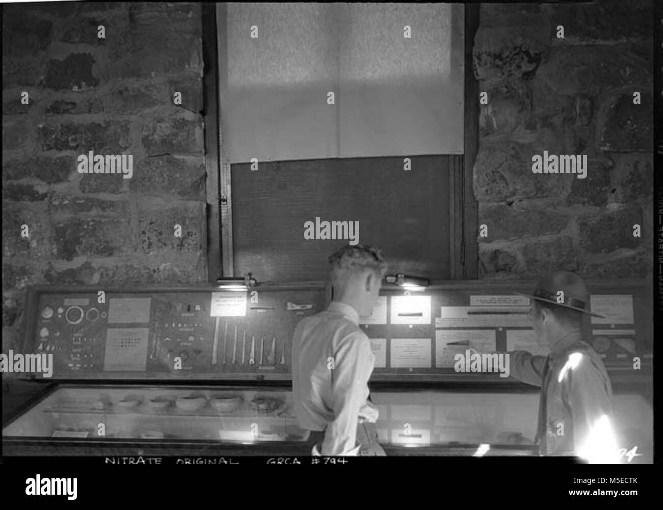 Grand Canyon Ranger interpretazione uniforme della RANGER CHE MOSTRA UN UOMO L'ANELLO ALBERO DI ESPORRE sul ciglio della strada Museo di Archeologia (TUSAYAN MUSEUM) interni. 18 AGO 1938 Foto Stock