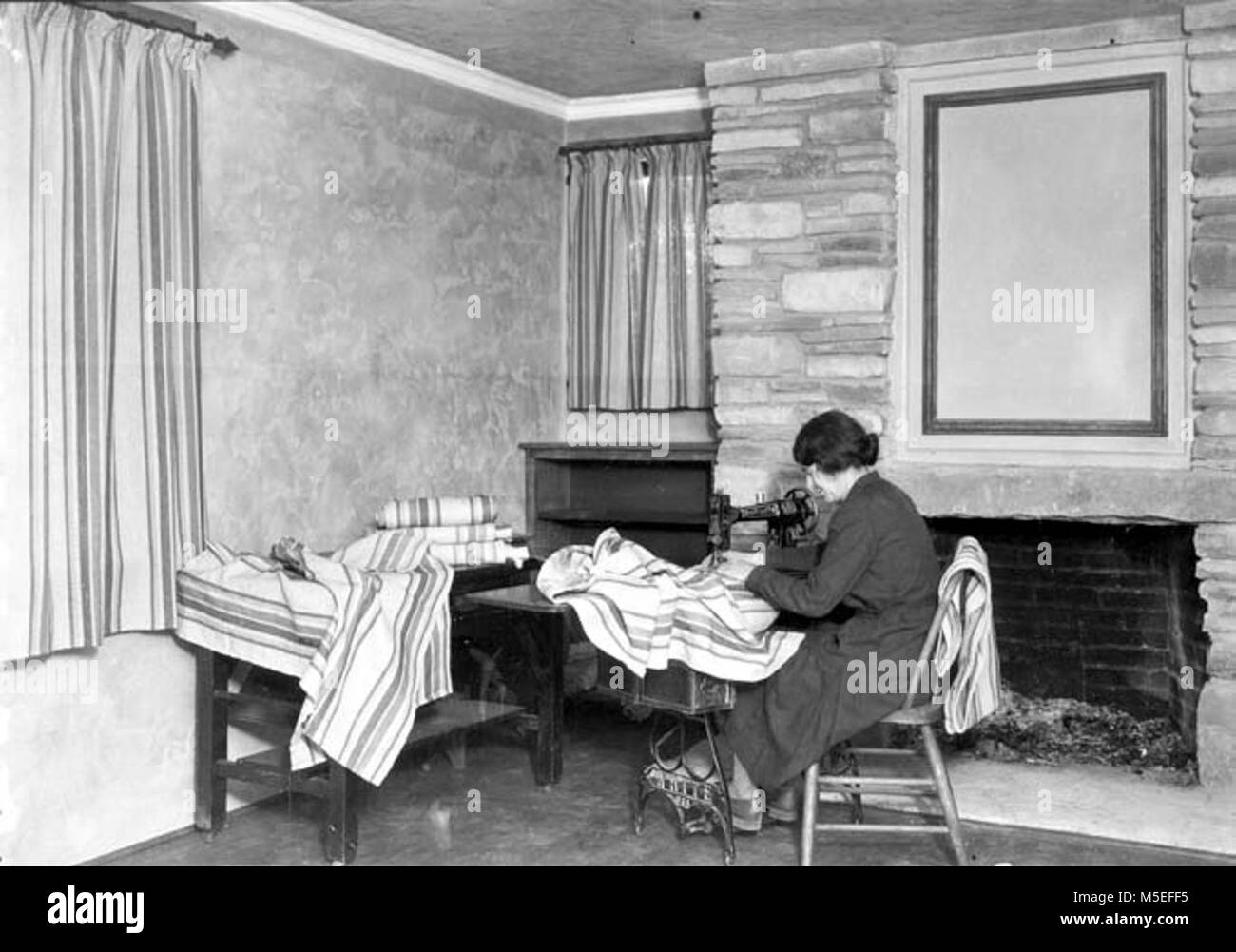 Grand Canyon dormitorio Ranger interno del dormitorio ranger. Donna seduta IN COMMONS camera la realizzazione di tende. CIRCA 1934. . Foto Stock
