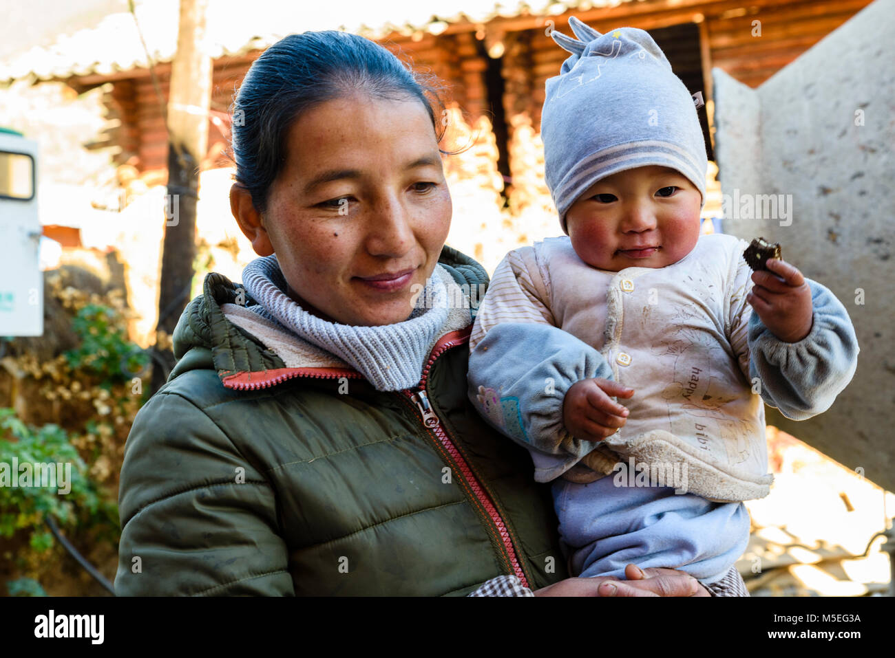 La madre e il bambino a Gesa antico borgo del Mosuo gruppo minoritario in Sichuan, in Cina Foto Stock