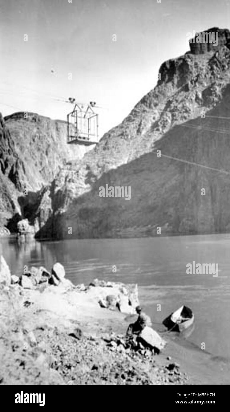 Grand Canyon - storico Fiume Colorado attraversamento del cavo c CAVO DI RUGGINE vettura tranviaria oltre il Fiume Colorado. Uomo seduto a terra con una piccola barca di tela (al di sotto del cavo.) circa 1911. Raccolta della ruggine. Foto Stock