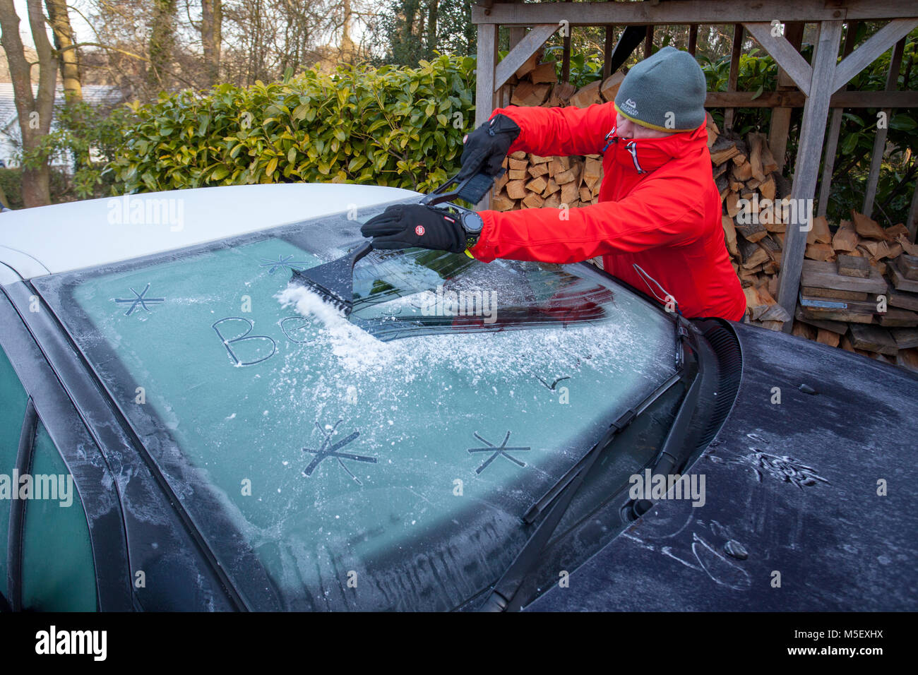 Flintshire, Wales, Regno Unito 23 febbraio 2018, UK meteo: Le temperature sono già cominciando a cadere come un artico massa aria si dirige verso il Regno Unito denominato â€oela bestia da est â€oebringing con molto freddo e neve nei prossimi giorni. Molti oggi si iniziano a sentire la come temperature è scesa ben al di sotto del congelamento la scorsa notte. Una persona cancellazione ice off di un parabrezza di automobile nel freddo e gelido meteo Lixwm, Flintshire Â© DGDImages/Alamy Live News Foto Stock