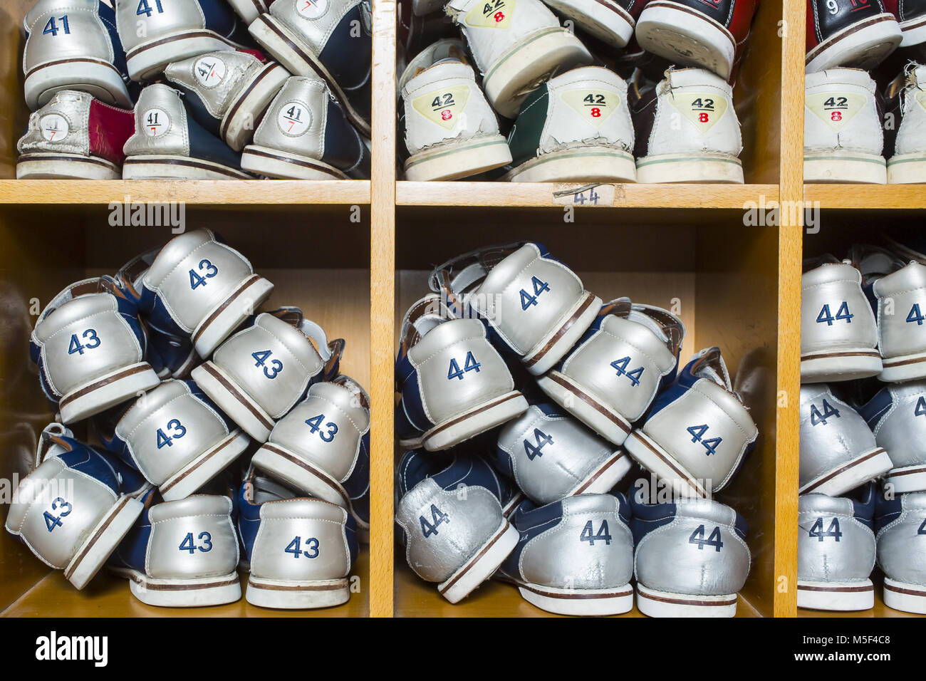 Rack con scarpe da bowling in diversi formati Foto Stock