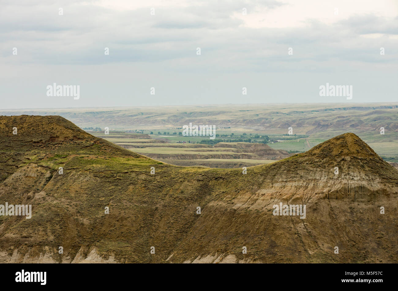 Alberta, Canada. Badlands in Red Deer River Valley vicino a Drumheller in una piovosa giornata di primavera con Dorothy città fantasma nella distanza. Foto Stock