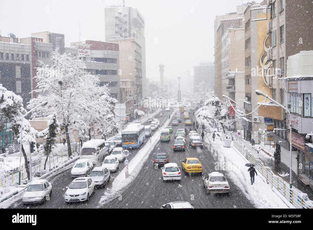 Dr fatemi street Tehran, Iran - 28 gennaio 2018 vetture passando attraverso la strada sulla giornata nevosa Foto Stock