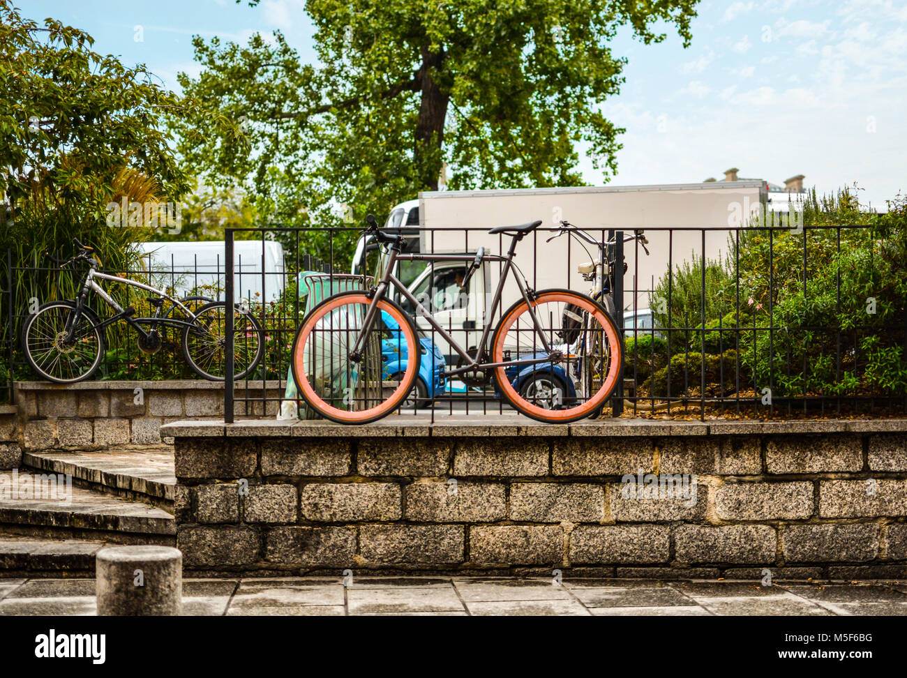 Biciclette compreso uno con colorati di rosa ruote parcheggiato su un marciapiede in Notre Dame quartiere di Parigi Francia. Foto Stock