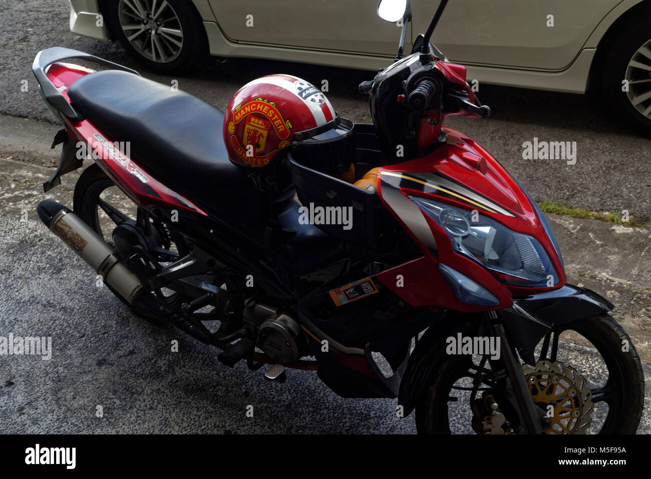 Il Manchester United casco parcheggiate su un motociclo, Kuching, Malesia, Borneo Foto Stock