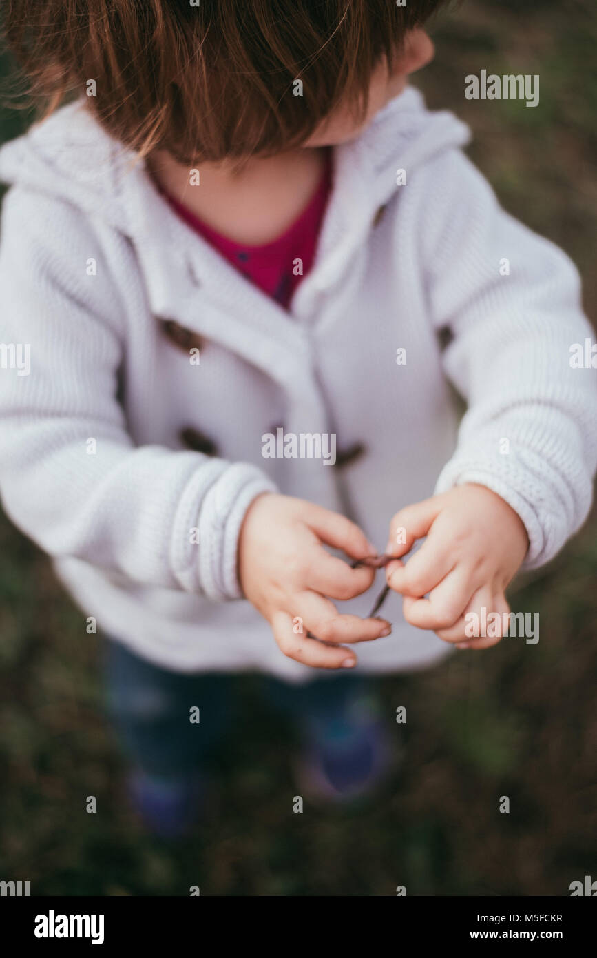Un bambino ragazza contiene un worm nelle sue mani in una fresca giornata di primavera. Foto Stock