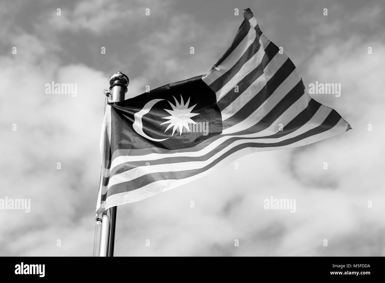 Malaysia bandiera noto anche come Jalur Gemilang wave con il blu del cielo. Persone battono bandiera in concomitanza con il Giorno di Indipendenza celebrazione o Merdeka Foto Stock