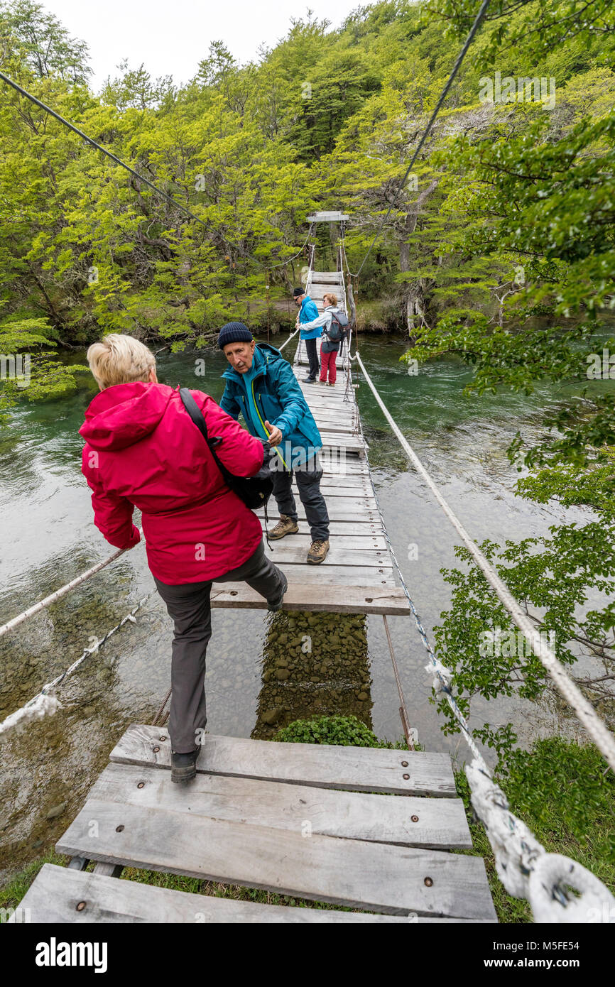 Trekker attraversa passerella sul Rio del Vuetas; Lago del Desierto; vicino a Reserva Provinciale del Lago del Desierto; Patagonia Argentina; Foto Stock