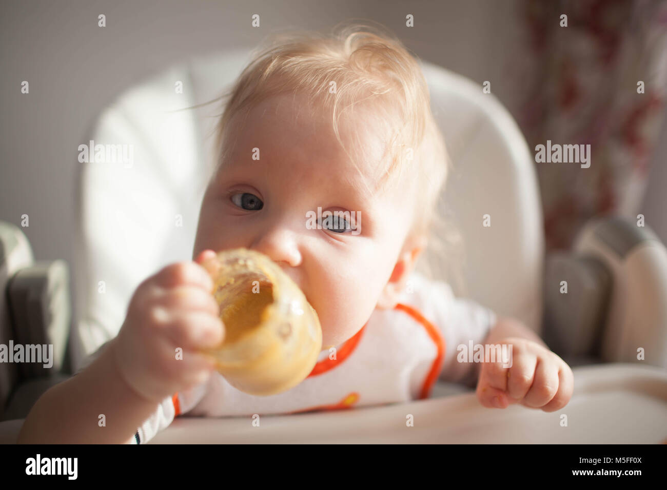 Il bambino di 6 mesi e lui per la prima volta tenta di squash vegetali. Cucchiaio per l'alimentazione Foto Stock