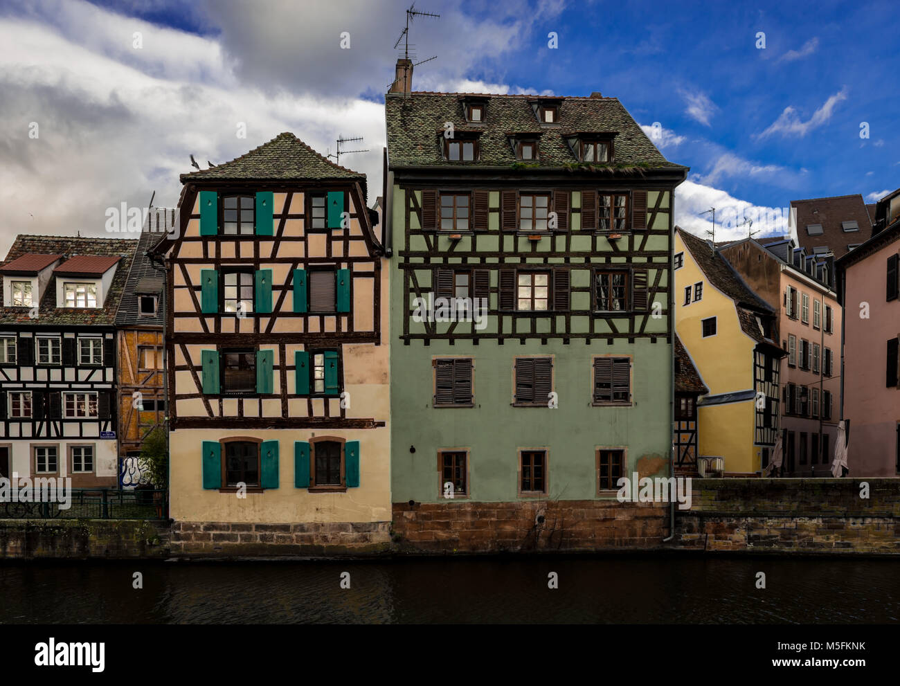 Tipiche case a graticcio dai canali del fiume Ill, in Little France, Strasburgo, Francia. Foto Stock