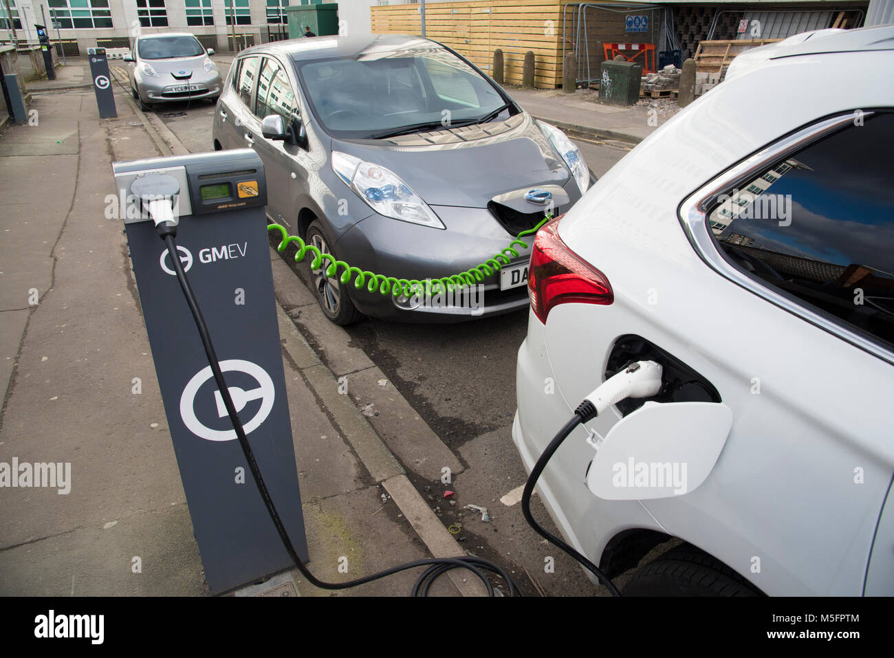 La ricarica di auto elettriche su una strada, Salford, Greater Manchester, Inghilterra, Regno Unito. Foto Stock